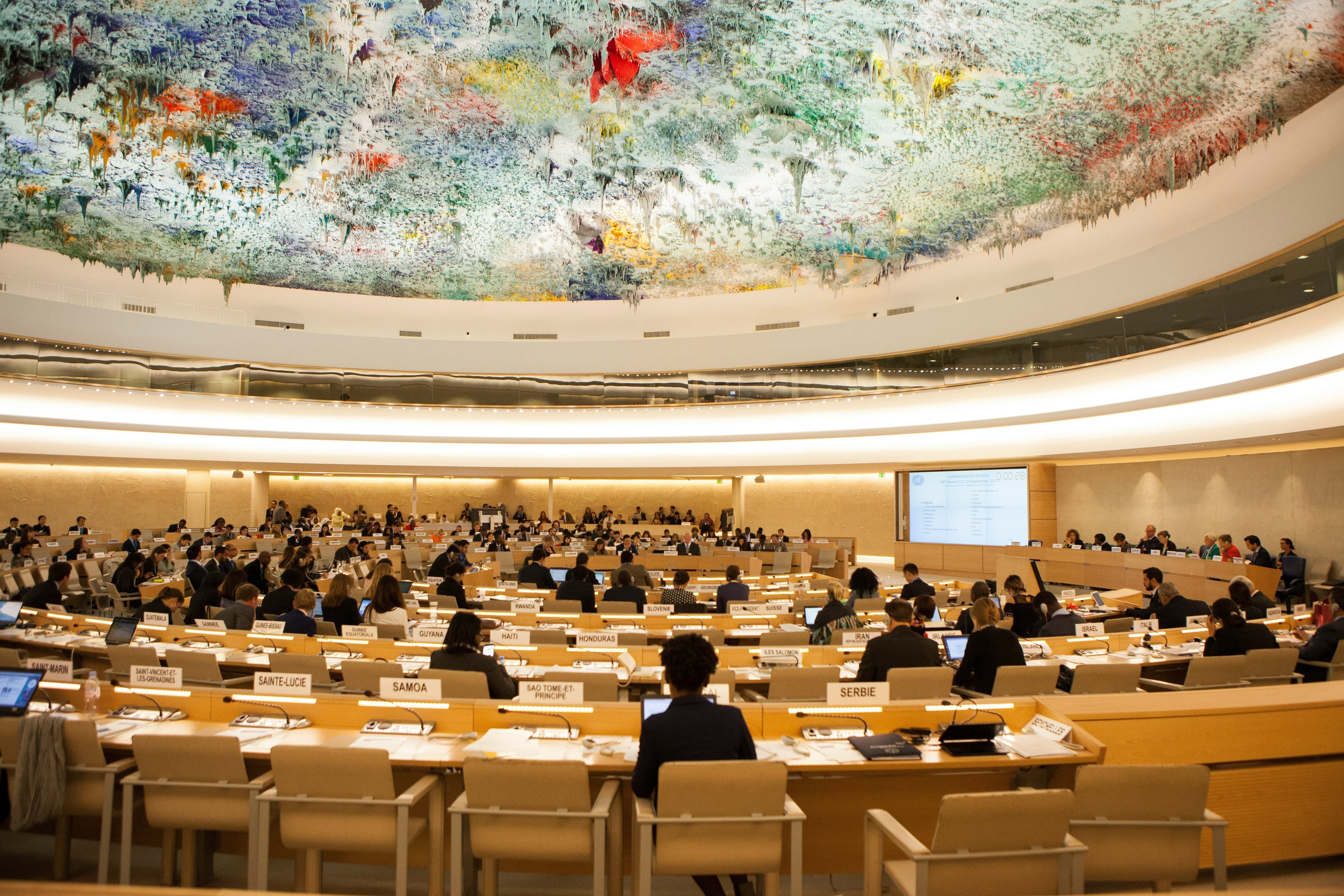 Delegates seated inside a large international institutional assembly chamber.