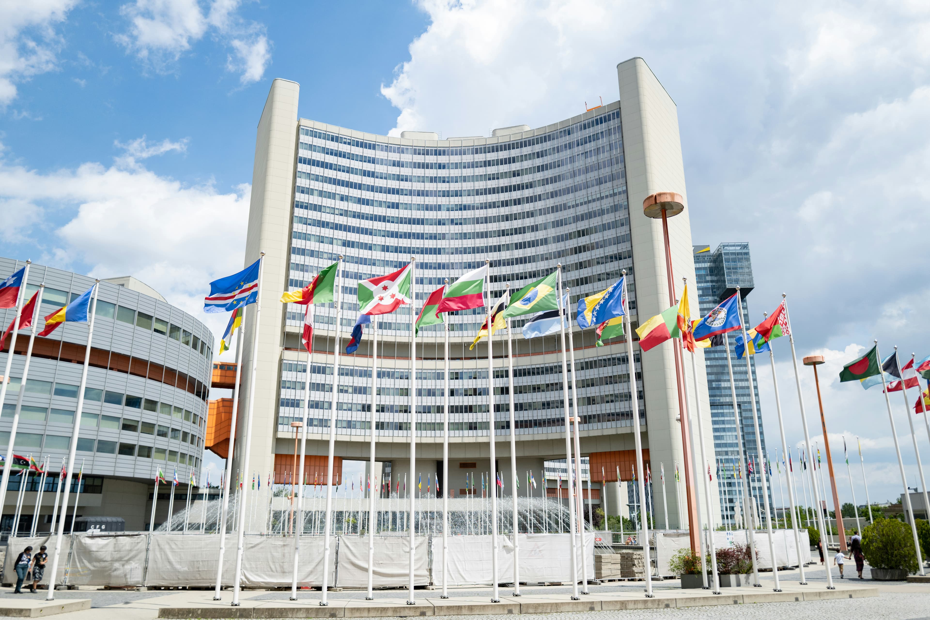 International flags displayed outside a large multilateral institutional building.